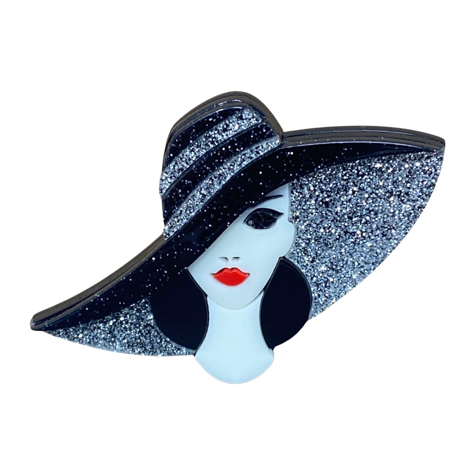 Handmade acrylic brooch featuring a stylish lady with a glittery black wide-brim hat on white background