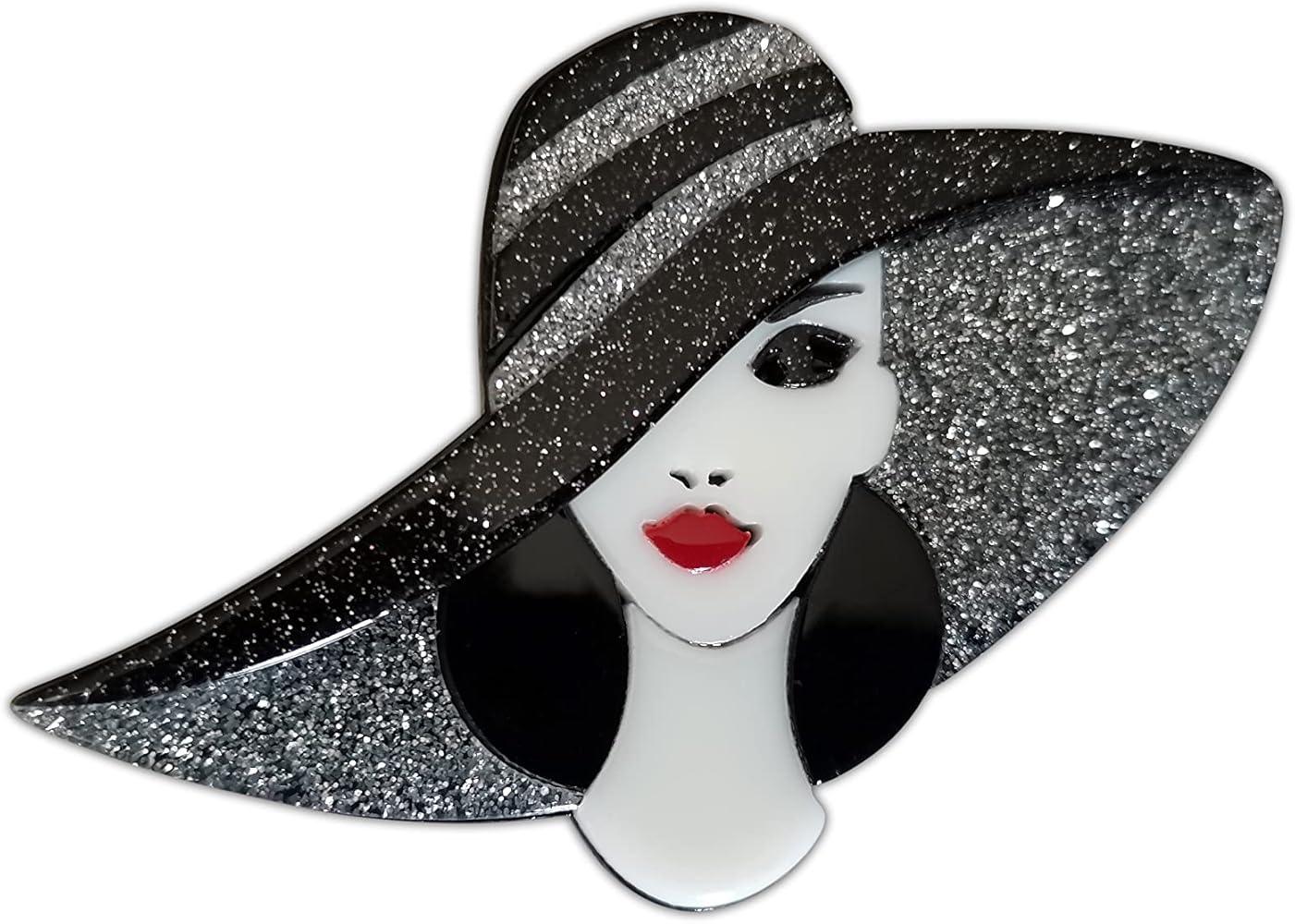 Handmade acrylic brooch featuring a stylish lady with a glittery black wide-brim hat, red lips, and an elegant design on a white background.