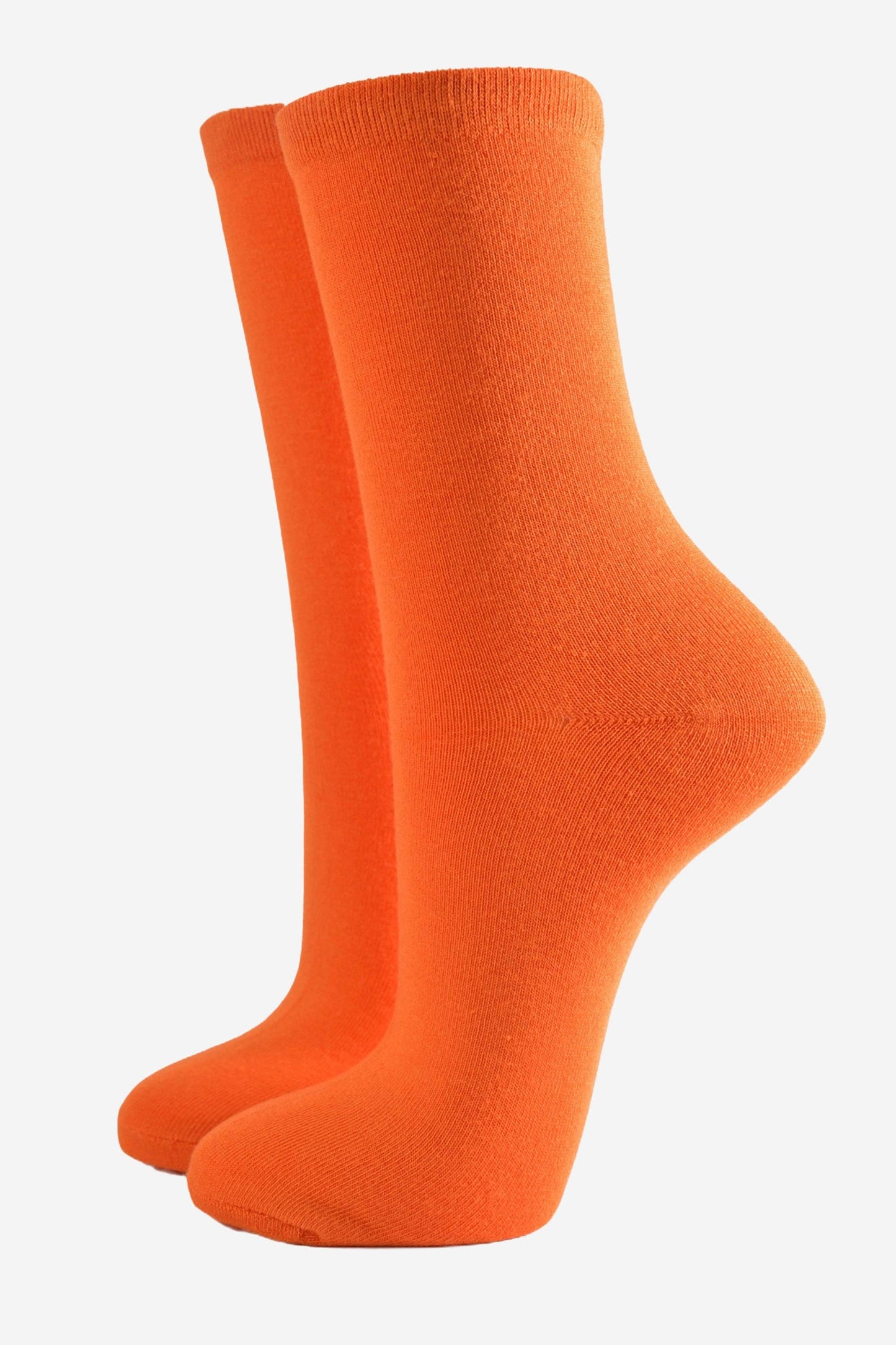 Close-up of bright orange bamboo socks for women showing the soft texture and knit.