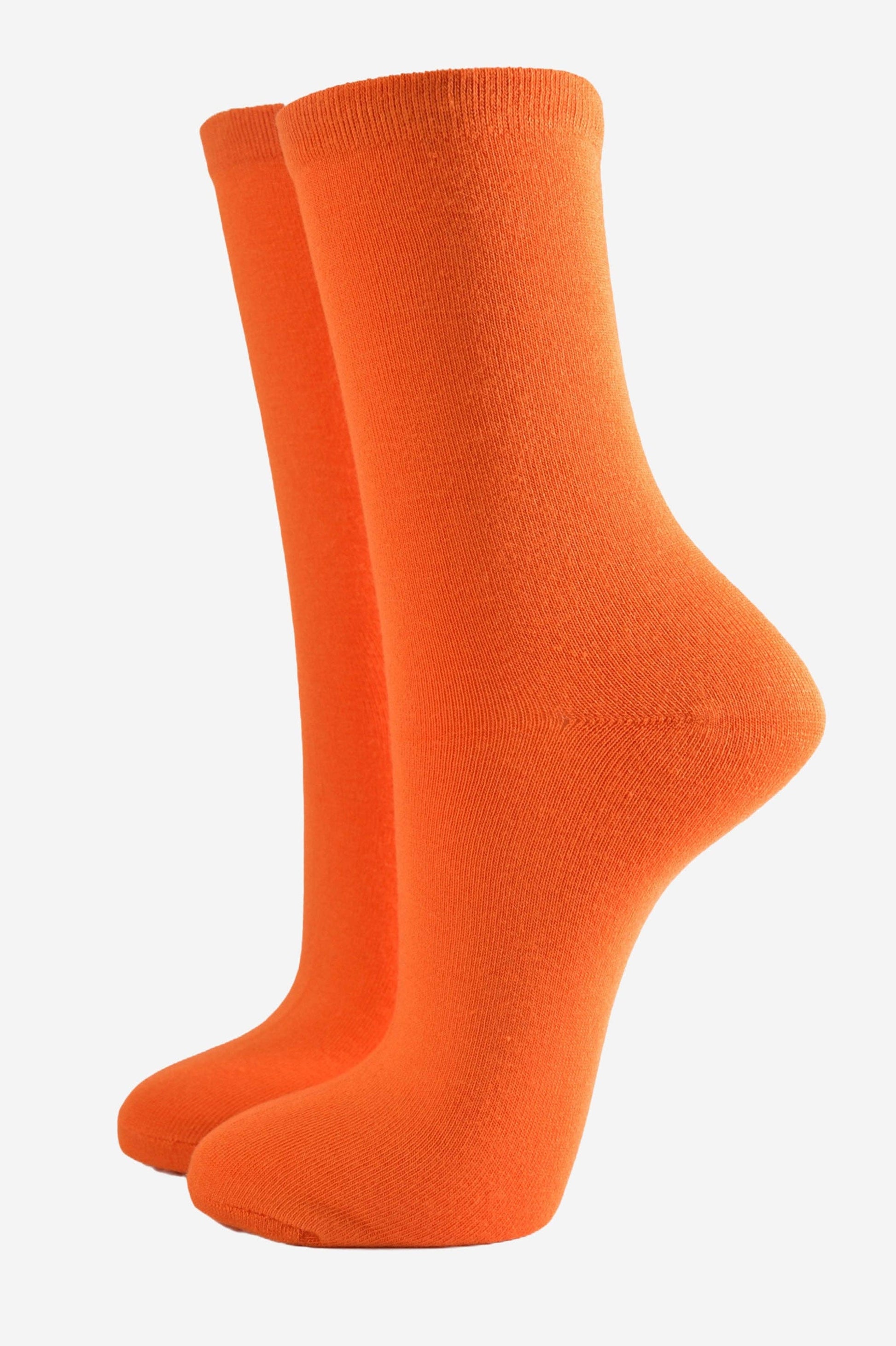 Close-up of bright orange bamboo socks for women showing the soft texture and knit.