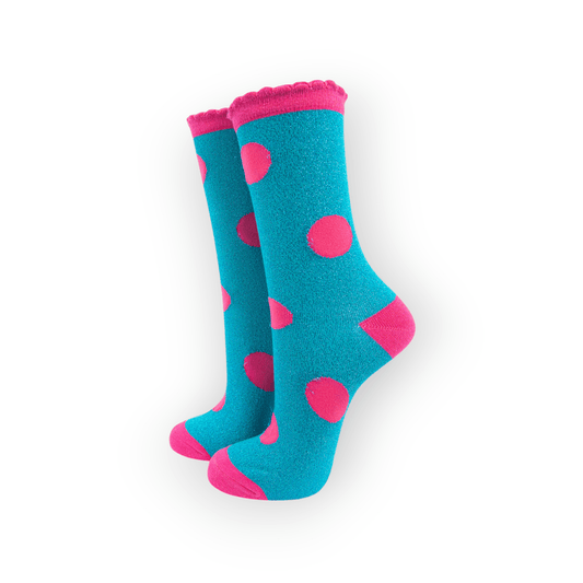 A pair of turquoise socks with large pink polka dots, pink heels and toes, and a scalloped pink cuff.